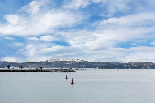 een grote hoeveelheid water met een brug op de achtergrond bij AWSA Deluxe Waterfront (4004) in Auckland
