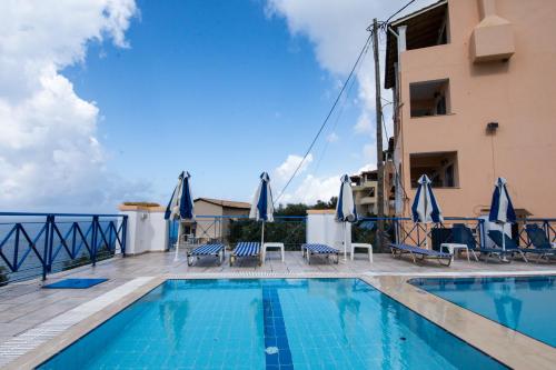 a swimming pool with chairs and a building at Lido Sofia Apartments in Agios Gordios