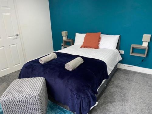 um quarto com uma cama com uma parede azul em 07 St Andrews em Lytham St Annes