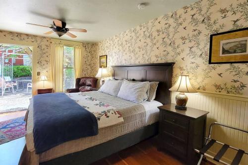a bedroom with a bed and a ceiling fan at Bluemoon Vacation Rentals - Anne Hathaway House in Ashland
