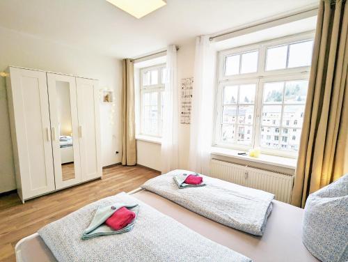 a bedroom with two beds and a window at Urlaubsmagie - Sauna & Whirlpool für alle - HW2 in Sebnitz