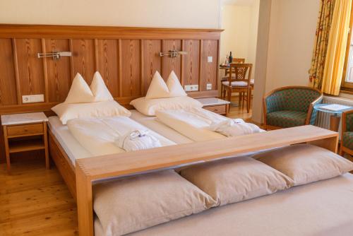 a large bed with four pillows on top of it at Hotel Ramsauhof Pool & Wellness Breakfast & Light Dinner Buffet in Ramsau am Dachstein