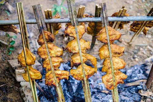 a bunch of food cooking on a grill at Khaosok August Freedom Camp in Khao Sok