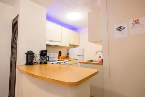 a kitchen with white cabinets and a wooden counter top at Jobos Beach Apartment A-3 in Isabela
