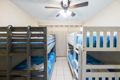 two bunk beds in a room with a ceiling fan at Jobos Beach Apartment A-3 in Isabela