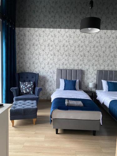 a bedroom with a bed and a chair at Apartament Black in Pasłęk