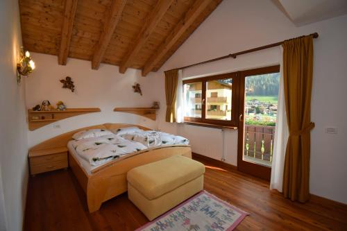 1 dormitorio con cama y ventana grande en Casa Dolores, en Padola