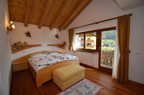 a bedroom with a bed and a large window at Casa Dolores in Padola