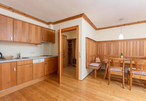a kitchen with wooden cabinets and a table and chairs at Hotel Ramsauhof Pool & Wellness Breakfast & Light Dinner Buffet in Ramsau am Dachstein