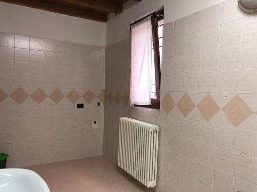 bagno con termosifone e finestra di La casetta della felicità, comodità tra Milano e Bergamo a Capriate San Gervasio