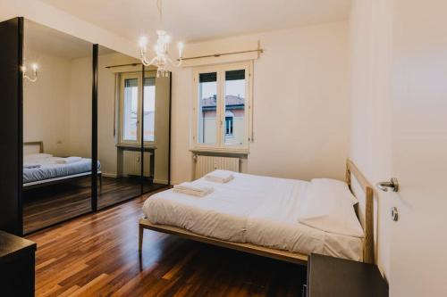 1 dormitorio con 1 cama grande y espejo en Palazzo San Zeno en Verona