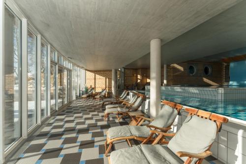 uma piscina com uma fila de cadeiras ao lado em Ramsauhof em Ramsau am Dachstein