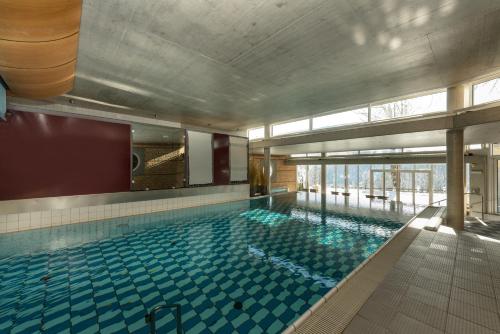 a large swimming pool in a building at Hotel Ramsauhof Pool & Wellness Breakfast & Light Dinner Buffet in Ramsau am Dachstein
