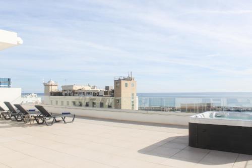 a balcony with chairs and a hot tub on a building at Aqua Apartments Bellamar, Marbella in Marbella
