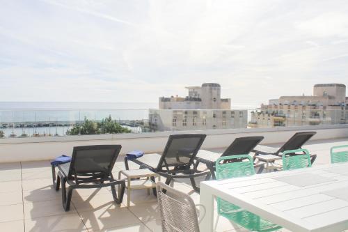 a group of chairs and a table on a balcony at Aqua Apartments Bellamar, Marbella in Marbella