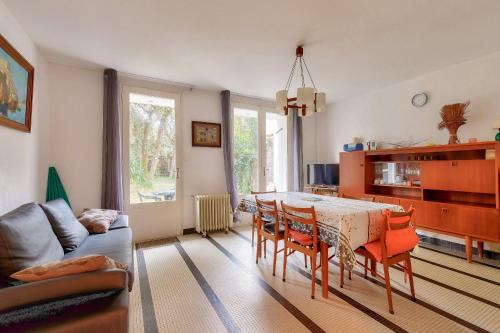 un salon avec une table, des chaises et un canapé dans l'établissement Maison pour 5 - 300m de la plage du Tanchet, à Les Sables-dʼOlonne