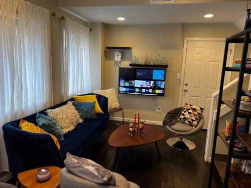 a living room with a blue couch and a tv at Knight Campbell Carriage House in Denver