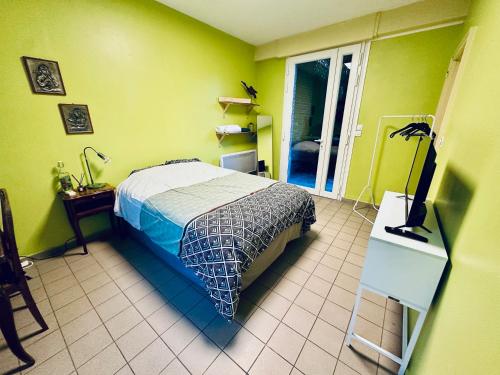 1 dormitorio con 1 cama en una habitación con paredes verdes en Chambre privée à louer, en Seclin