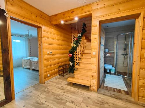 a bathroom with wooden walls and a staircase in a room at Chata nad Roztokami in Mchawa