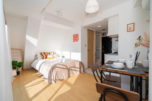 a bedroom with a bed and a table and a kitchen at Aurora 5 in Tokyo