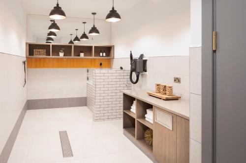 a kitchen with white walls and a counter and a tv at Modern King's Cross Apartments in London