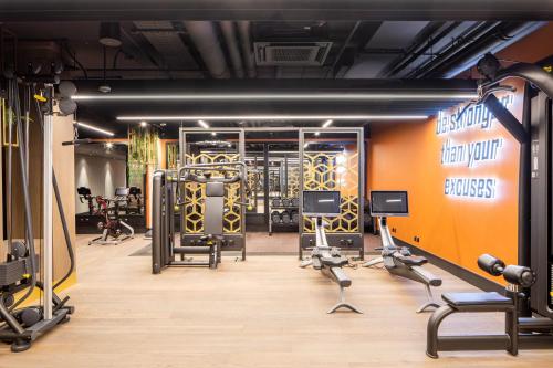 a gym with several treadmills and exercise equipment at Modern King's Cross Apartments in London