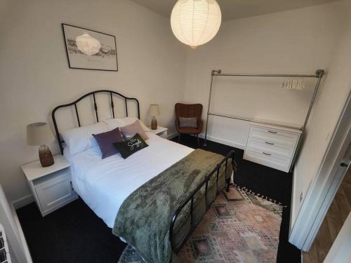 a bedroom with a large bed and a chair at New Build Cosy Bungalow near Bath and Bristol in Wick