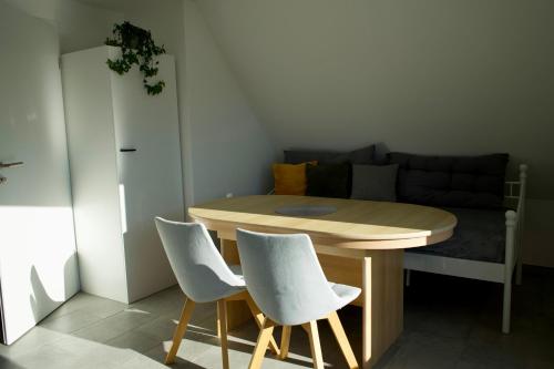 einen Tisch und Stühle in einem kleinen Zimmer mit einem Sofa in der Unterkunft Haus Allgäu Wohnung Wertachauen in Türkheim