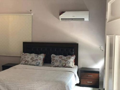 een slaapkamer met een bed met een zwart hoofdeinde bij Hotel Sky Inn Clifton in Karachi
