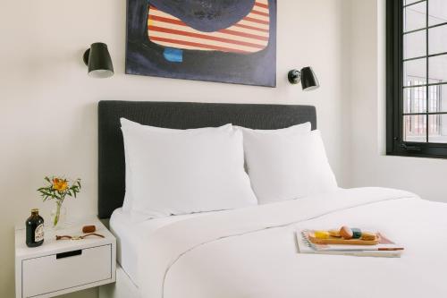 Sonder The Industrialist في بروكلين: غرفة نوم مع سرير أبيض كبير مع طاولة جانبية