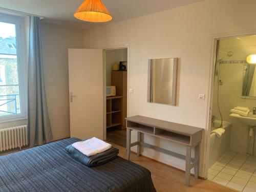 1 dormitorio con cama, lavabo y escritorio en Résidence Le Rochebonne en Saint-Malo