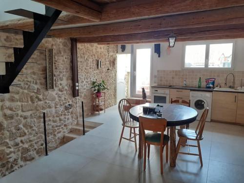 une cuisine et une salle à manger avec une table et des chaises dans l'établissement Maison restaurée à l'ancienne avec terrasse, à Jouques