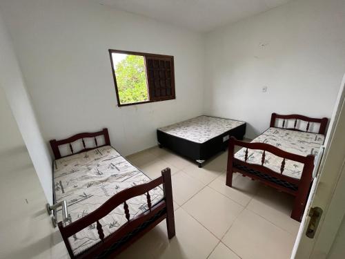 Ceará-MirimにあるCasa de Praia Muriu Beachのベッド2台と窓が備わる客室です。