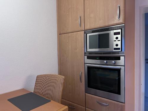 a kitchen with a microwave oven and a table at Allee zum See in Schüttorf