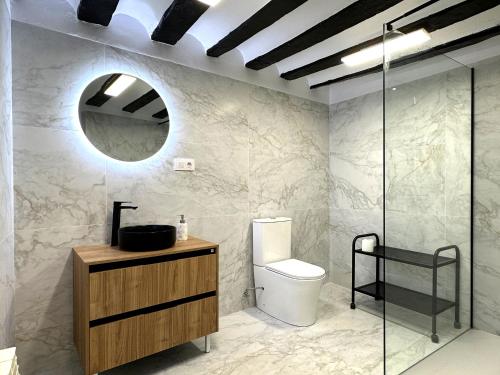 a bathroom with a toilet and a sink and a mirror at LA CAPRICHOSA DE ALCOR in Bozoo