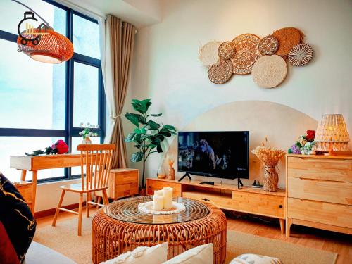 a living room with a television and a table at 1 min to Seaview & Sunrise Heart of Kuantan in Kuantan