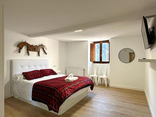 a bedroom with a bed with a red blanket at LA CAPRICHOSA DE ALCOR in Bozoo