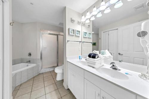 La salle de bains blanche est pourvue d'un lavabo et de toilettes. dans l'établissement Destin West Gulfside Two Bedroom with Bunks!!! Lazy River!!, à Fort Walton Beach