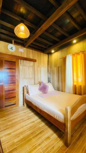 a bedroom with a large bed in a room at Cabin A at Bigang Munti in Batangas City