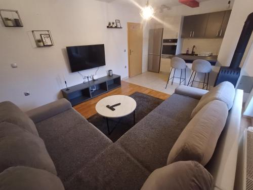 a living room with a couch and a table at Vikendica Mila in Kupres