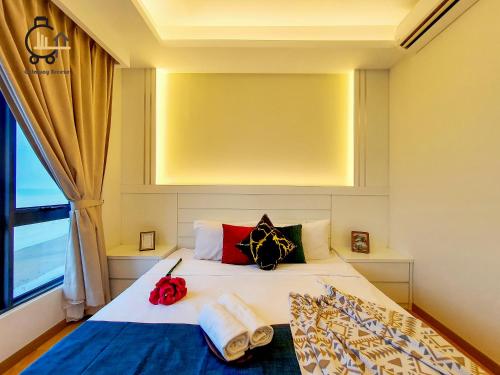 a bedroom with a bed with pillows and a window at 1 min to Seaview & Sunrise Heart of Kuantan in Kuantan