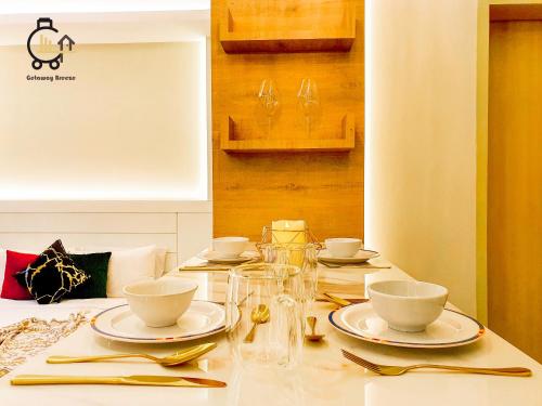 a table with plates and bowls and glasses on it at 1 min to Seaview & Sunrise Heart of Kuantan in Kuantan