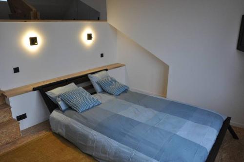 ein Schlafzimmer mit einem blauen Bett mit zwei blauen Kissen in der Unterkunft Magnifique logement, 2 chambres, in Péruwelz