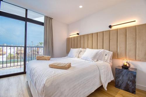 a bedroom with a large bed with a large window at Suite Guinea 506 by Homestaygrancanaria in San Bartolomé de Tirajana