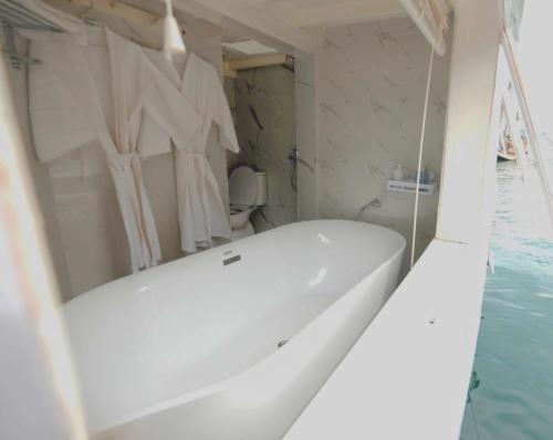 a white bath tub in a bathroom with water at Phinisi sailing Komodo 3 days 2 night in Labuan Bajo