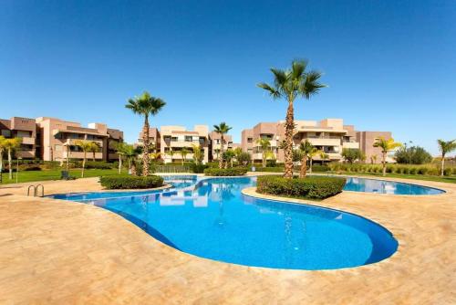 een zwembad in een resort met palmbomen bij Cosy Apartment 2 Bedrooms Golf City in Marrakesh