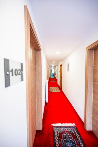 a red carpet in a hallway with doors and a red rug at Die Schlafstube - Bed & Breakfast in Zeltweg