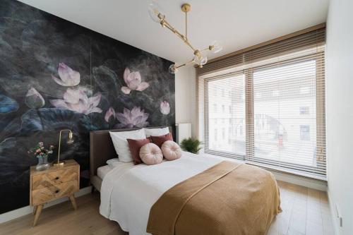 a bedroom with a large bed with a floral wallpaper at Luxury Apart - Młyn Maria in Wrocław