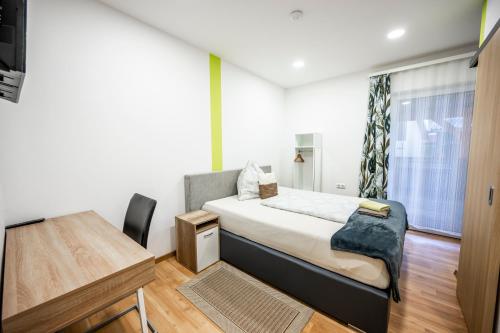 a bedroom with a bed and a desk and a window at Die Schlafstube - Bed & Breakfast in Zeltweg