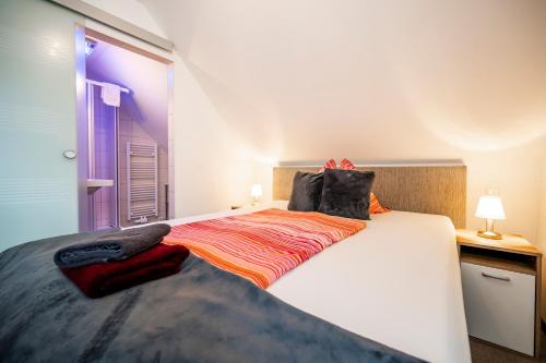 a bedroom with a large white bed with an orange blanket at Die Schlafstube - Bed & Breakfast in Zeltweg